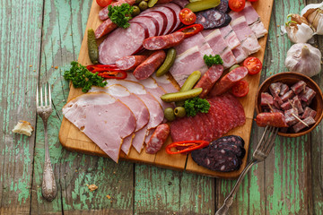 Charcuterie board with sausages and smoked meat. Top view.