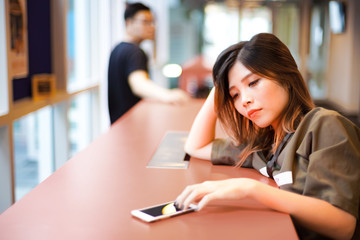 Lonely sad girl waiting for text message from smartphone | Couple separated from each other