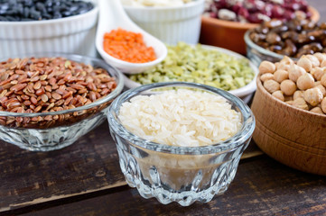 Healthy food dieting nutrition concept, vegan protein and carbohydrate source. Assortment of colorful raw legumes in bowls on a wooden table.