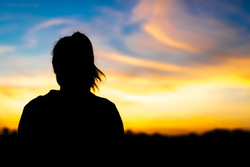 Fototapeta premium Silhouette woman standing sad in the sunset.