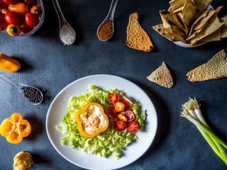 Fresh vegetarian dinner with lots of vegetables and eggs on white plate. Arrangement of vegetarian food on black texture background.