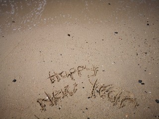 Happy New Year written on the beach