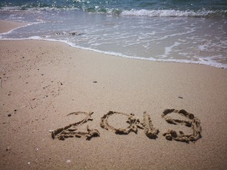 Happy New Year written on the beach