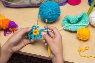The girl knits a flower from thread, close-up