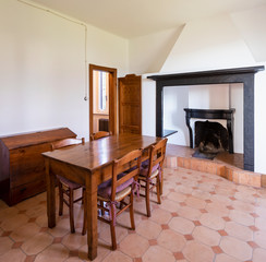 Dining room with table, wooden chairs and a stone fireplace