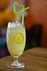 A glass of lemon ice tea with tube in heart shape