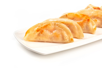 A closeup photo of gyozas, Asian dumplings, on a white background with a place for text