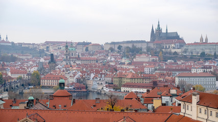 Fototapeta na wymiar Prague castle view from astronomical tower, top view of Prague city with layer of red roof.
