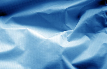 Crumpled transparent plastic surface in navy blue color.