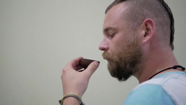 A Guy With A Beard And A Mohawk Drinking  Tea From A Bowl