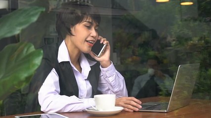 Businesswoman talking on phone at coffee shop.