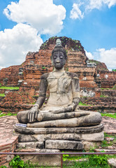 Ancient statues of sitting Buddha image in front of remains of main Phra Pang at Wat Mahathat. The old Buddhism ruins in Ayutthaya, Thailand, Southeast Asia.