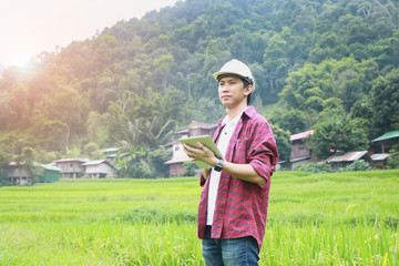 Smart Farming.Management Information System using technologies in agriculture.farmer with tablet computer in field using apps and internet of things(IOT) in production and agricultural research © mansong