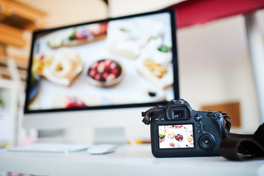 Background image of photo camera with photo of food on table against computer with editing software, copy space