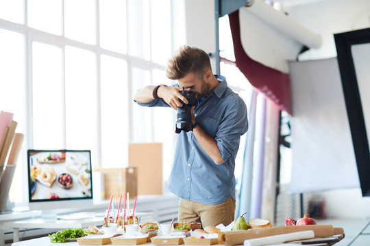 Portrait of male photographer doing food-photography while working in studio, copy space