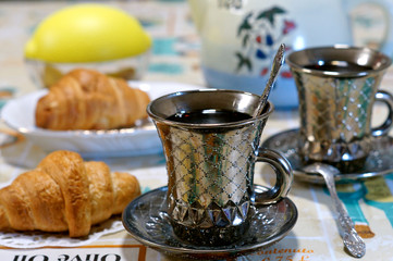 Two cups of tea with croissants on the kitchen table