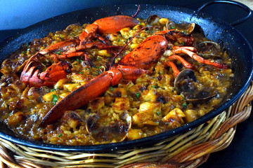 Paella de arroz con bogavante,  almejas y calamares.