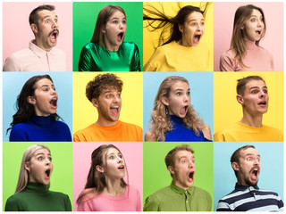 The surprised and astonished young woman and man screaming with open mouth isolated on colorful...