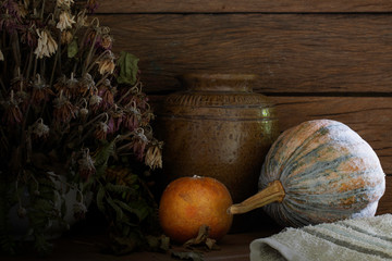 Rotten oranges with withered flowers in the vase and dim light