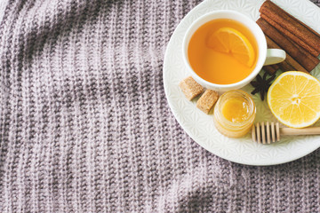 Cup of tea with lemon and cookies, honey and cinnamon sticks, star anise on the blanket.. Christmas, winter concept.