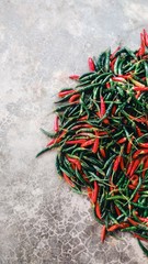 Naklejka premium Red and green chili pepers on concrete floor