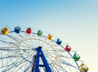 Underside view of a ferris wheel over blue sky