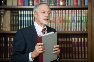 Businessman holding a book in a library