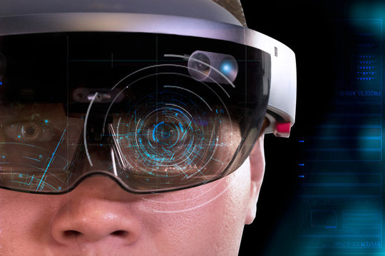 Portrait of young man with 3D virtual reality glasses hololens on dark background