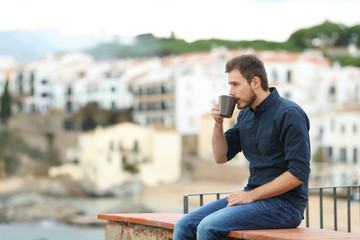 Man looking away drinking coffee on vacation