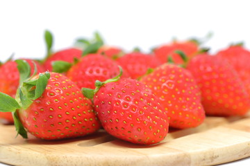red strawberry on wooden plate