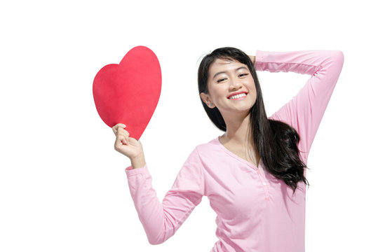 Happy asian woman holding red paper heart