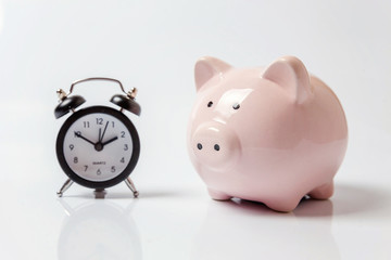 Pink piggy bank and classic alarm clock isolated on white background. Saving time investment budget wealth business retirement, financial, money, banking concept. Copy space