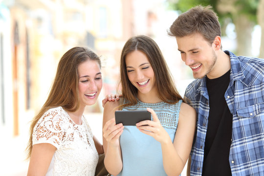 Teenage friends watching media on a smartphone