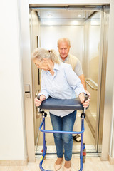 Seniorin mit Rollator in einem Fahrstuhl