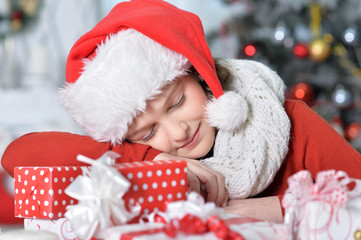 Portrait of happy girl in Santa hat sleeping