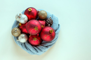 Christmas balls is wrapped in a warm scarf. Concept-preparation for the celebration of the New year, Christmas, festive mood.
