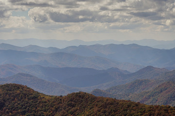 Obraz na płótnie Canvas rolling mountain landscape with fall color foliage and forest and blue haze in the Blue Ridge mountains of North Carolina