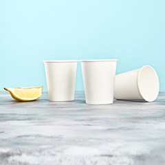 white coffee cup on peach background. disposable paper dishes. Copy space for logo, text or brand