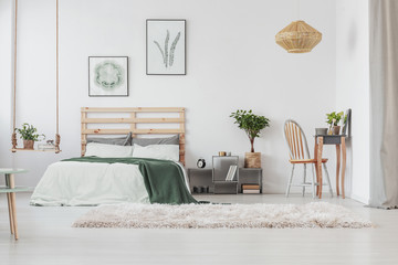 Scandinavian bedroom interior with elegant dresser and warm carpet, minimal posters in black frames...