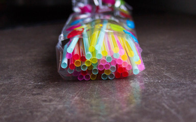 Colorful tubes for juice in bulk. Bright festive background.