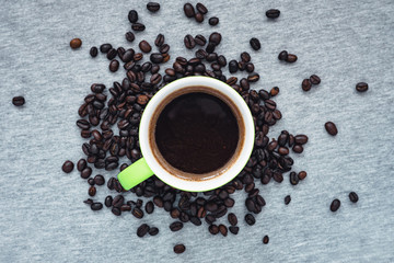 cup of coffee with beans on grey background