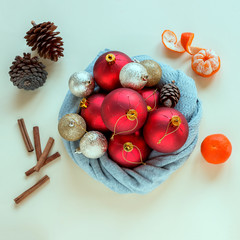 Christmas balls and fir cones  is wrapped in a warm scarf. Fragrant cinnamon sticks and tangerines create an atmosphere of celebration. Concept-preparation for  the New year, Christmas.