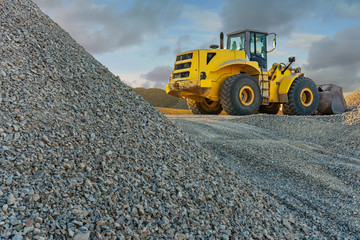 Excavator in an outdoor mine perform stone movement