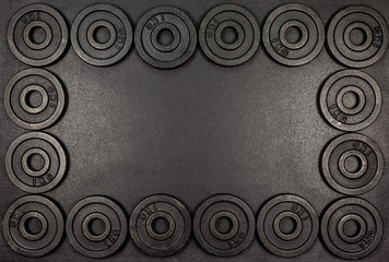 Frame made from black metal weights 1kg on black background with copy sapce.