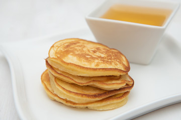 Pancakes and honey. In white porcelain plates