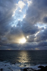 荒れる海と雲の切れ間の陽射し