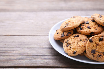 Chocolate chip cookies on plate on grey wooden background