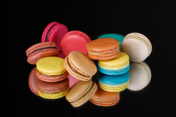 Fototapeta na wymiar Colorful macarons dessert in pastel colors on a black background.