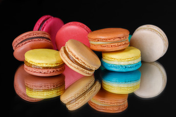 Colorful tasty sweet macaroons dessert on black background.