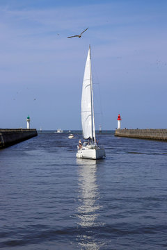sailboat entering the harbor of deauville